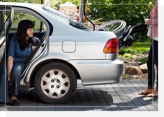 A woman sitting in the drivers seat of her car.